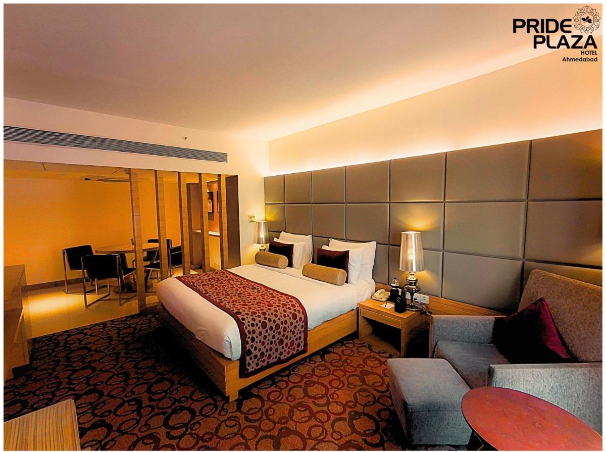 a hotel room with a bed and a couch at Pride Plaza Hotel, Ahmedabad in Ahmedabad
