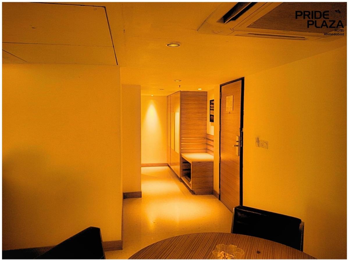 a room with a hallway with a table and a chair at Pride Plaza Hotel, Ahmedabad in Ahmedabad