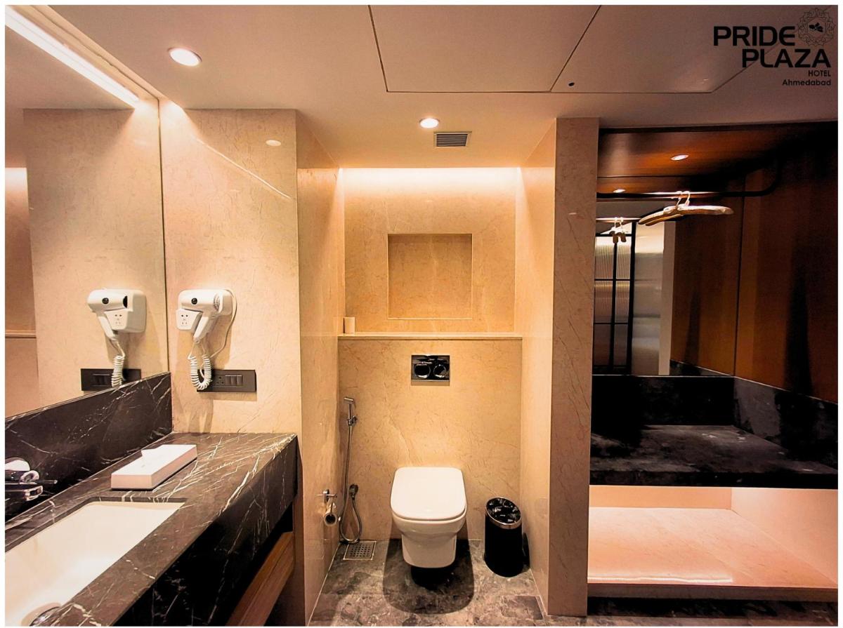 a bathroom with a toilet and a sink at Pride Plaza Hotel, Ahmedabad in Ahmedabad