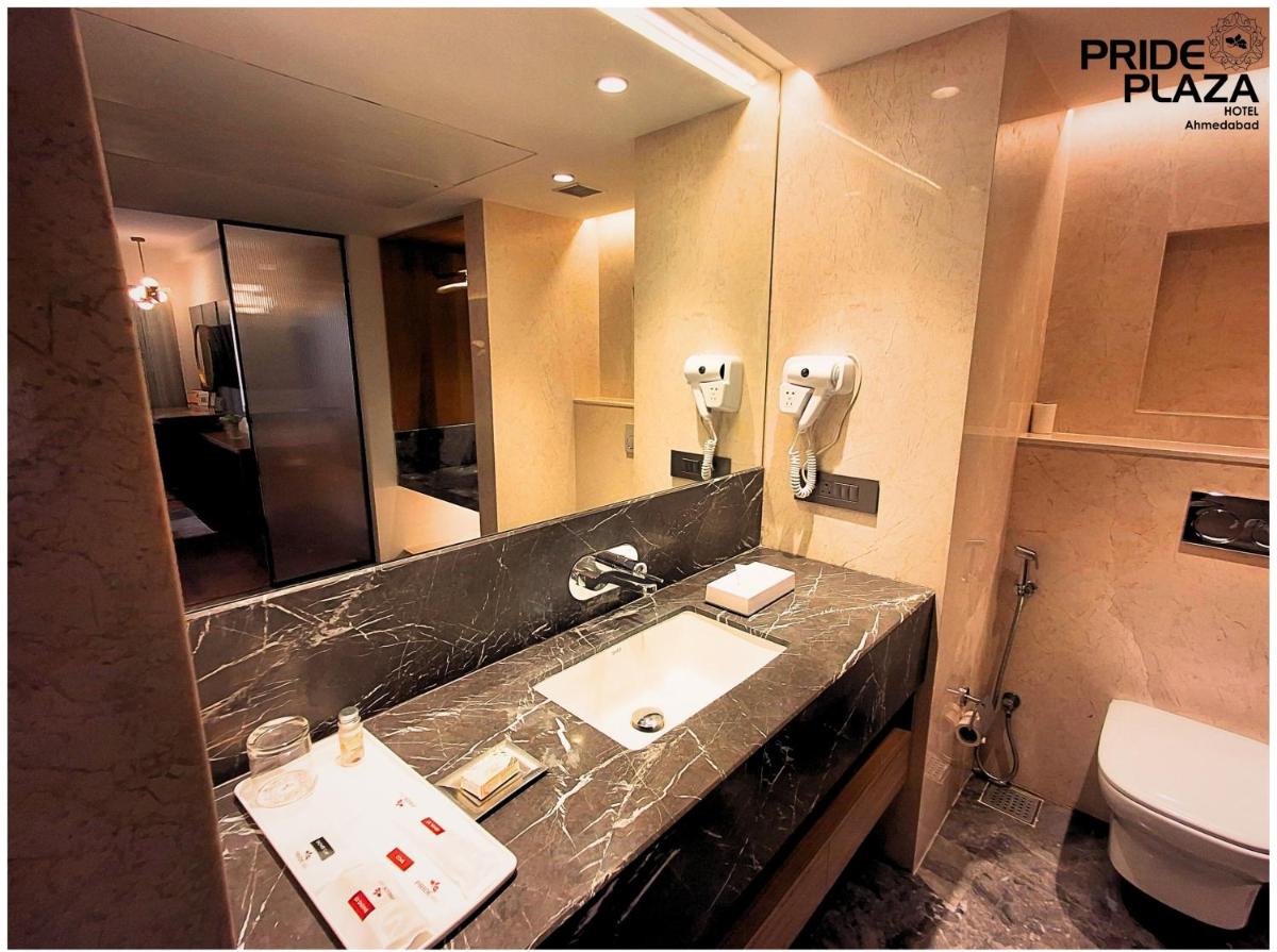 a bathroom with a sink and a toilet at Pride Plaza Hotel, Ahmedabad in Ahmedabad