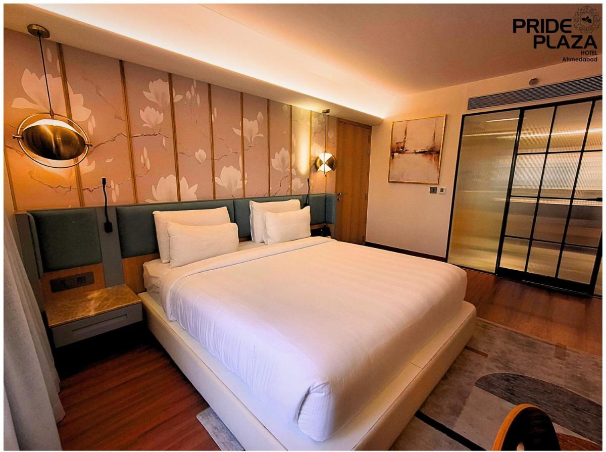 a bedroom with a large white bed in a room at Pride Plaza Hotel, Ahmedabad in Ahmedabad