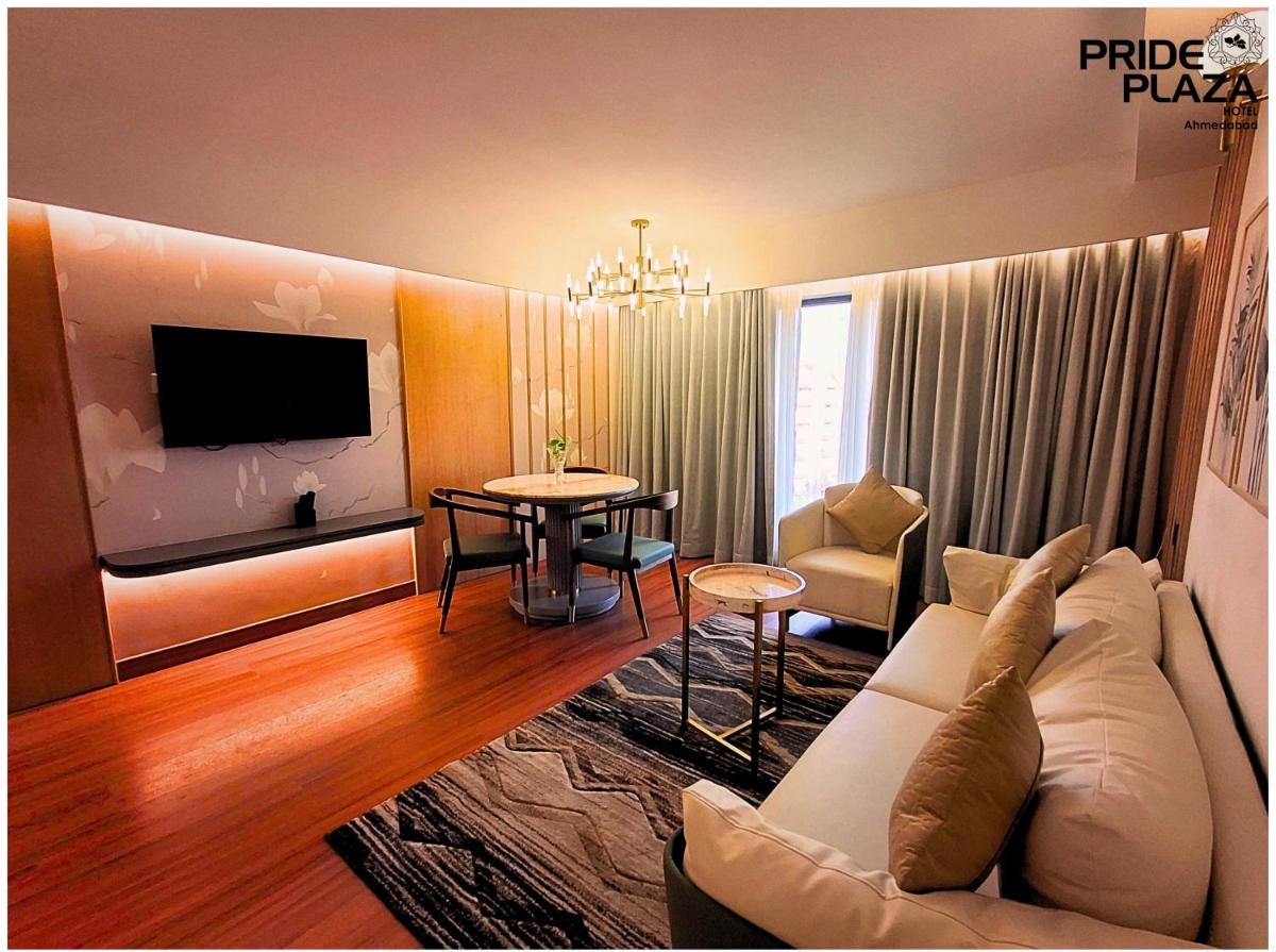a living room with a couch and a table at Pride Plaza Hotel, Ahmedabad in Ahmedabad