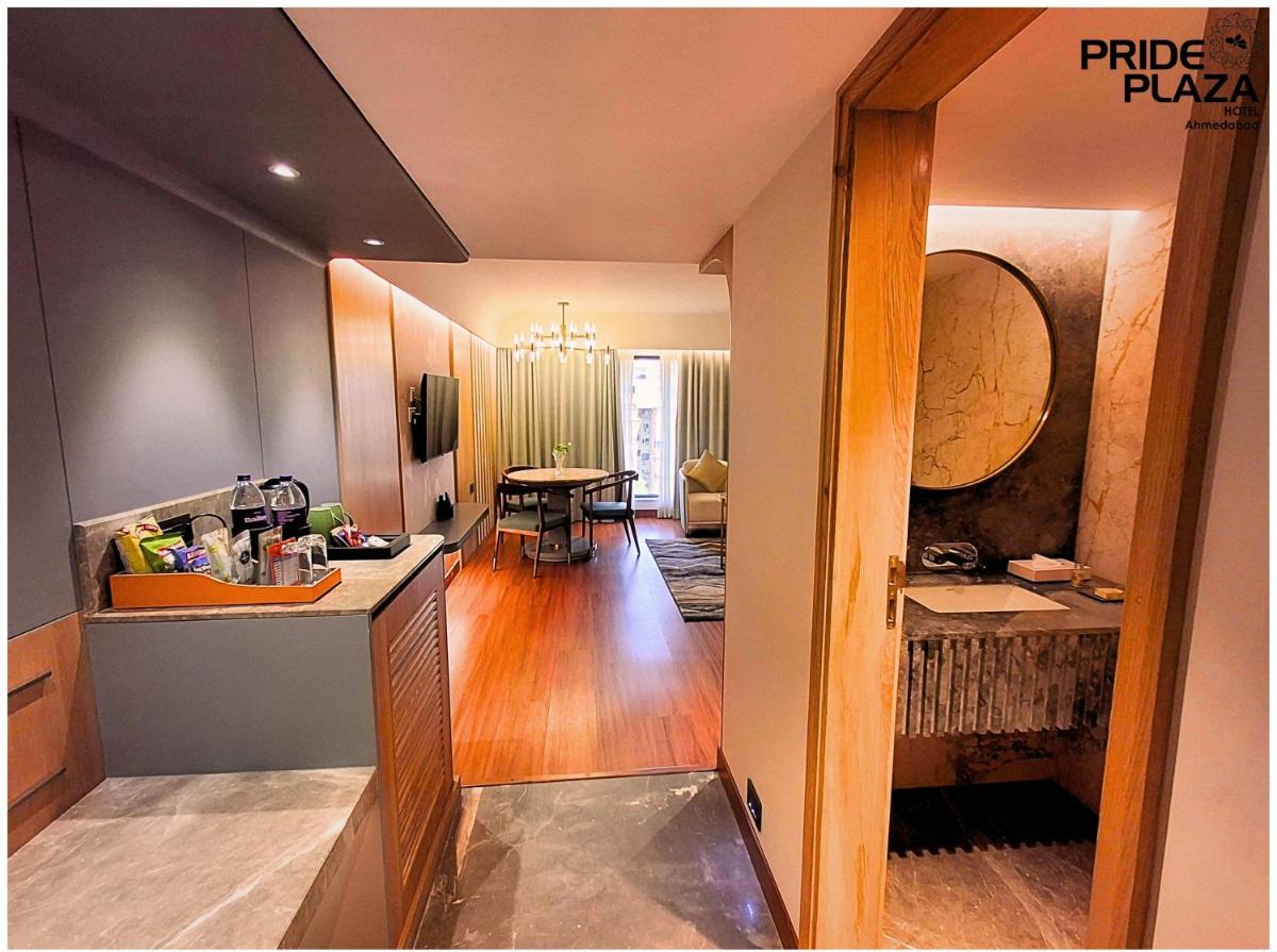 a kitchen and living room with a table in a room at Pride Plaza Hotel, Ahmedabad in Ahmedabad a kitchen and living room with a table in a room at Pride Plaza Hotel, Ahmedabad in Ahmedabad