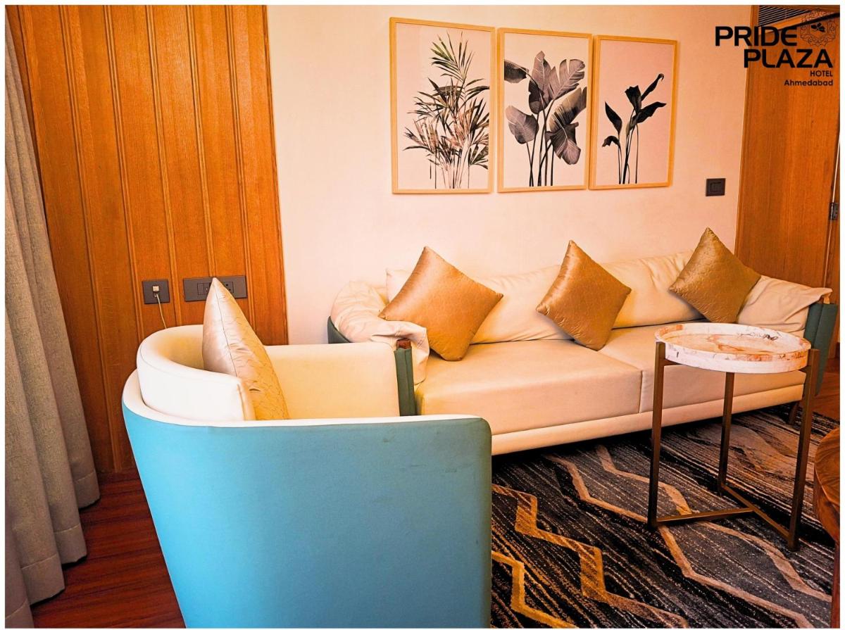 a living room with a couch and a table at Pride Plaza Hotel, Ahmedabad in Ahmedabad
