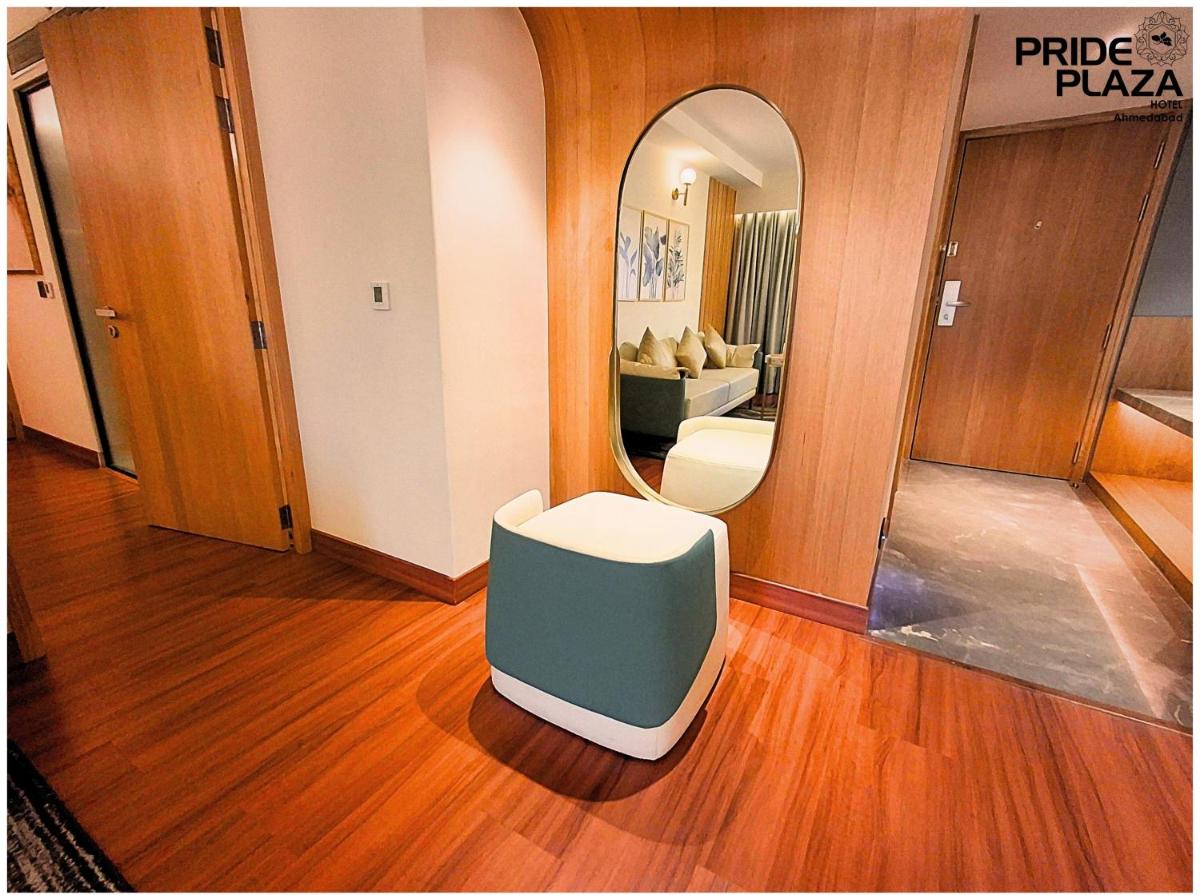 a room with a mirror and a chair in a room at Pride Plaza Hotel, Ahmedabad in Ahmedabad