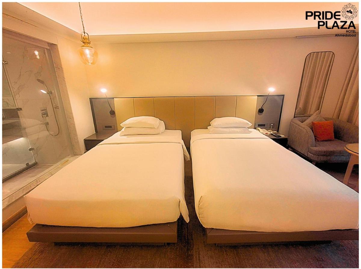 two twin beds in a hotel room with at Pride Plaza Hotel, Ahmedabad in Ahmedabad