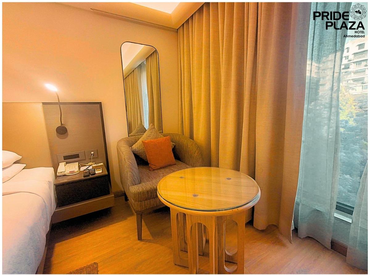 a hotel room with a table and a bed at Pride Plaza Hotel, Ahmedabad in Ahmedabad