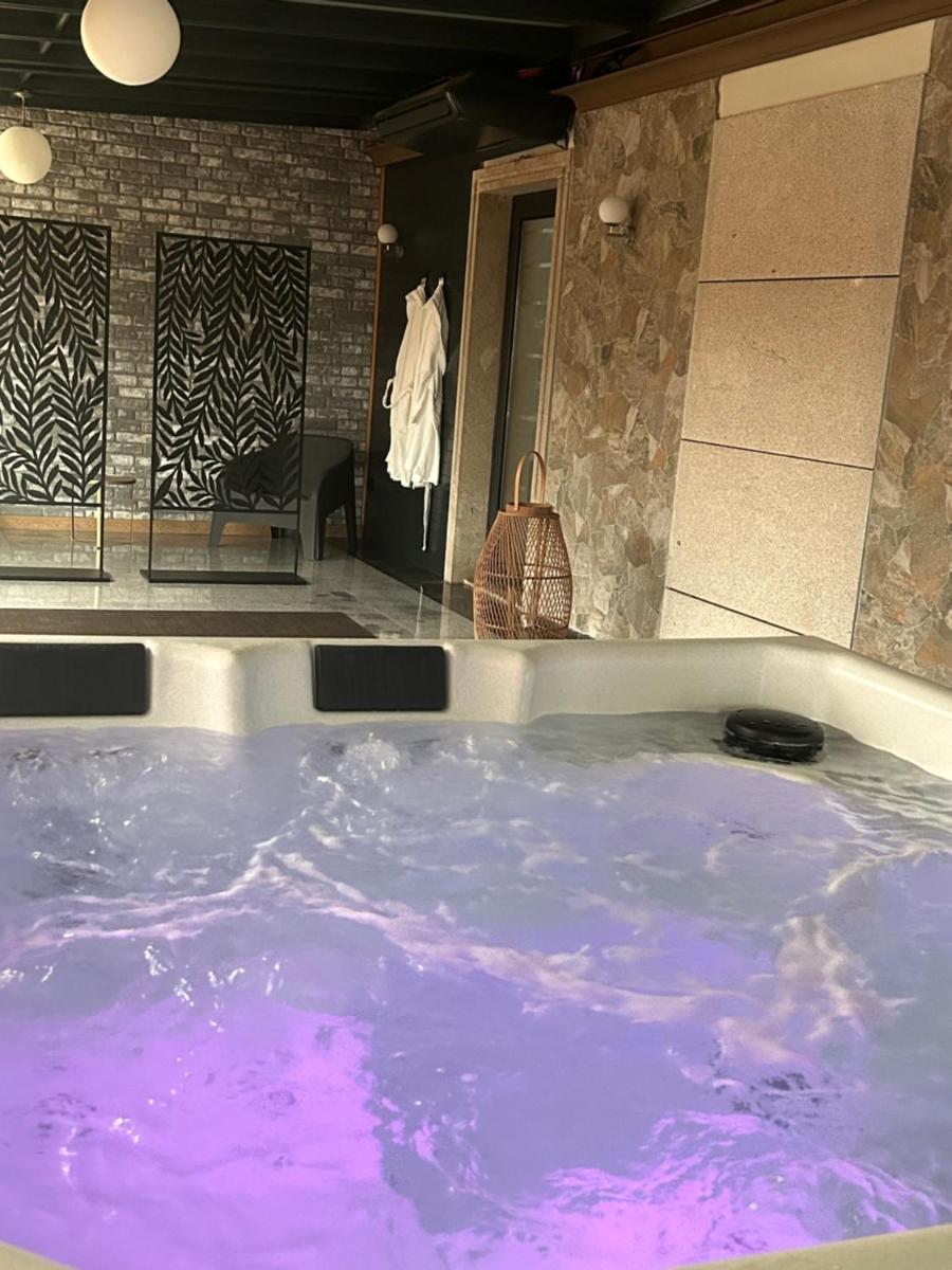 jacuzzi con agua púrpura en una habitación en Hotel Alfonso I, en Tui