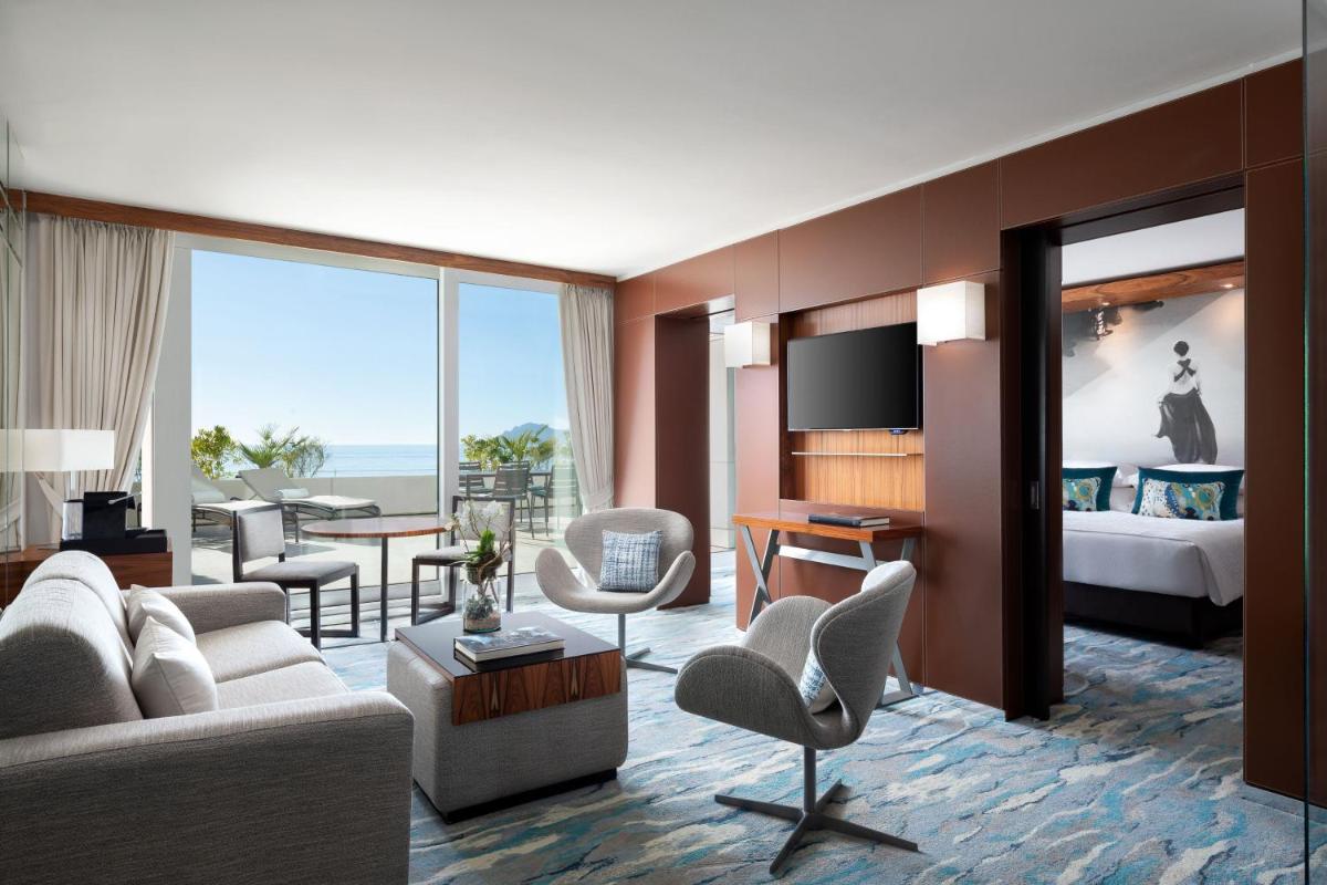 un salon avec un canapé et une chambre avec un lit dans l'établissement JW Marriott Cannes, à Cannes