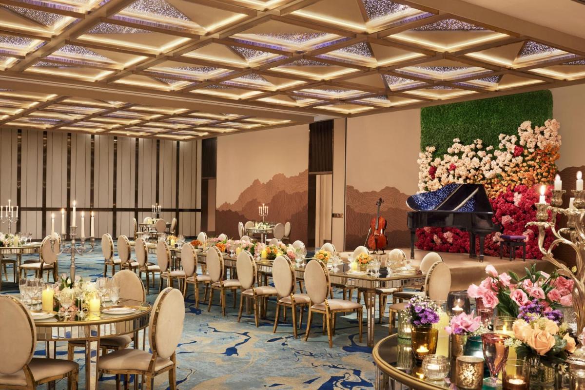 a ballroom with tables and chairs and a grand piano at JW Marriott Mumbai Juhu in Mumbai +123 photos