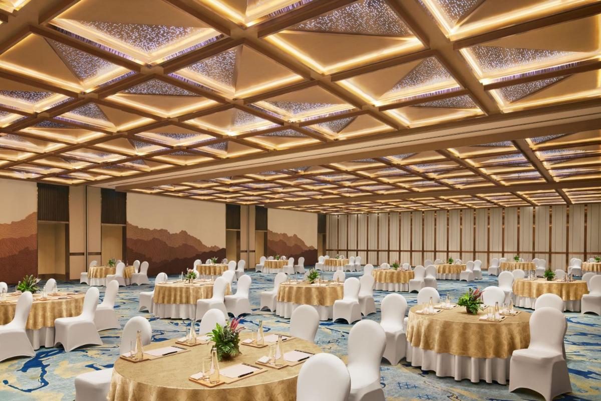 a large banquet hall with tables and white chairs at JW Marriott Mumbai Juhu in Mumbai
