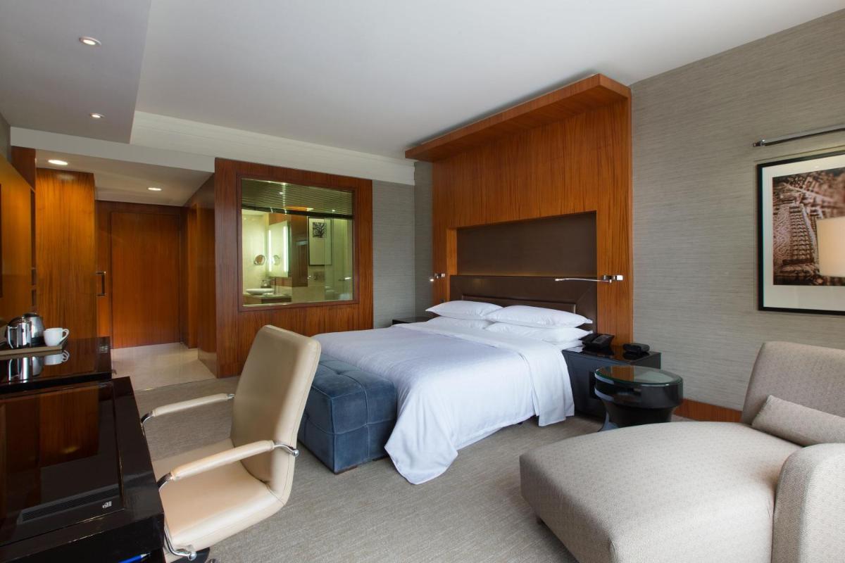 a hotel room with a bed and a living room at Sheraton Grand Bangalore Hotel at Brigade Gateway in Bengaluru