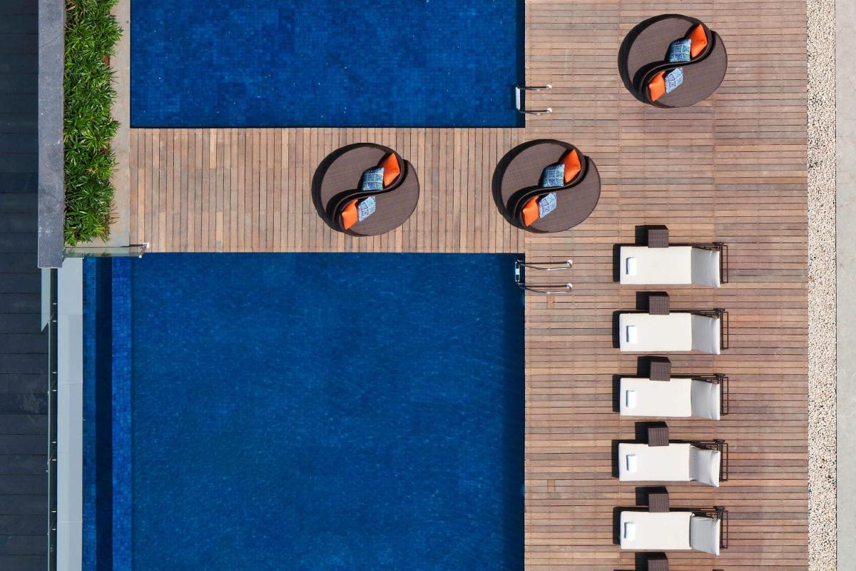 an overhead view of a swimming pool with lounge chairs at Sheraton Grand Bangalore Hotel at Brigade Gateway in Bengaluru