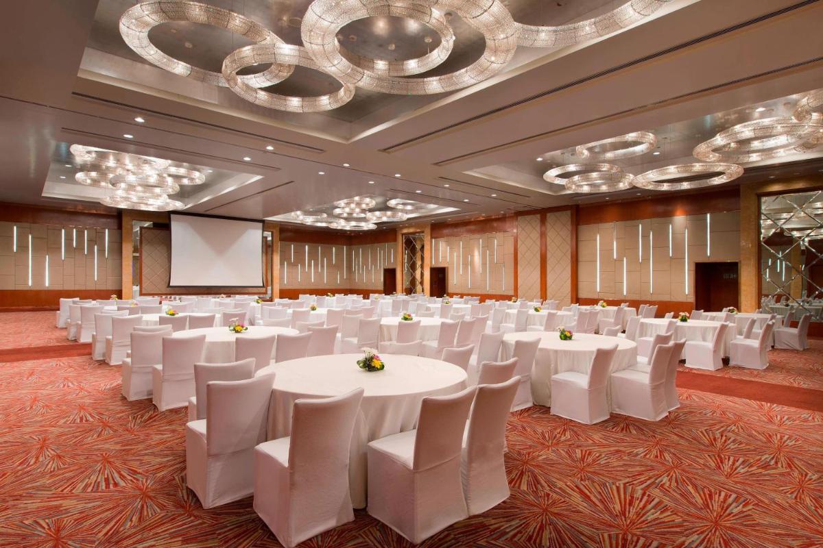 a conference room with white tables and white chairs at Sheraton Grand Bangalore Hotel at Brigade Gateway in Bengaluru