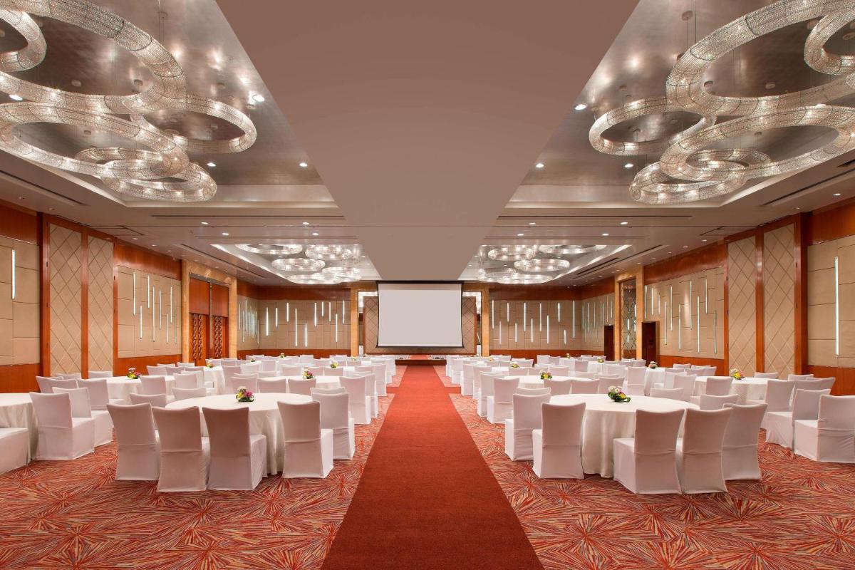 a banquet hall with white tables and white chairs at Sheraton Grand Bangalore Hotel at Brigade Gateway in Bengaluru