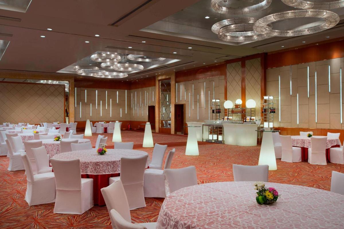 a banquet hall with white tables and white chairs at Sheraton Grand Bangalore Hotel at Brigade Gateway in Bengaluru