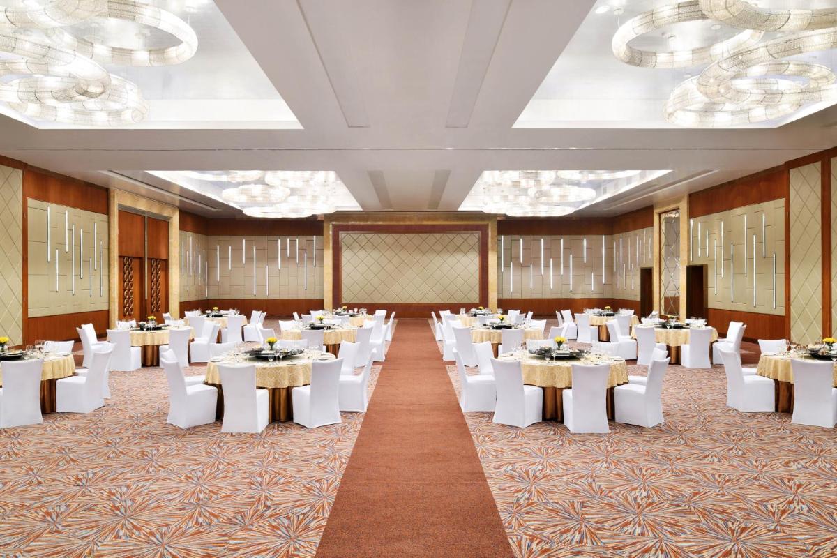 a banquet hall with white tables and white chairs at Sheraton Grand Bangalore Hotel at Brigade Gateway in Bengaluru +73 photos