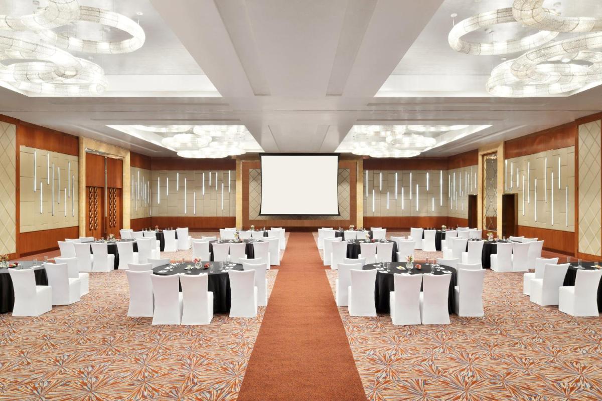 a conference room with white tables and white chairs at Sheraton Grand Bangalore Hotel at Brigade Gateway in Bengaluru