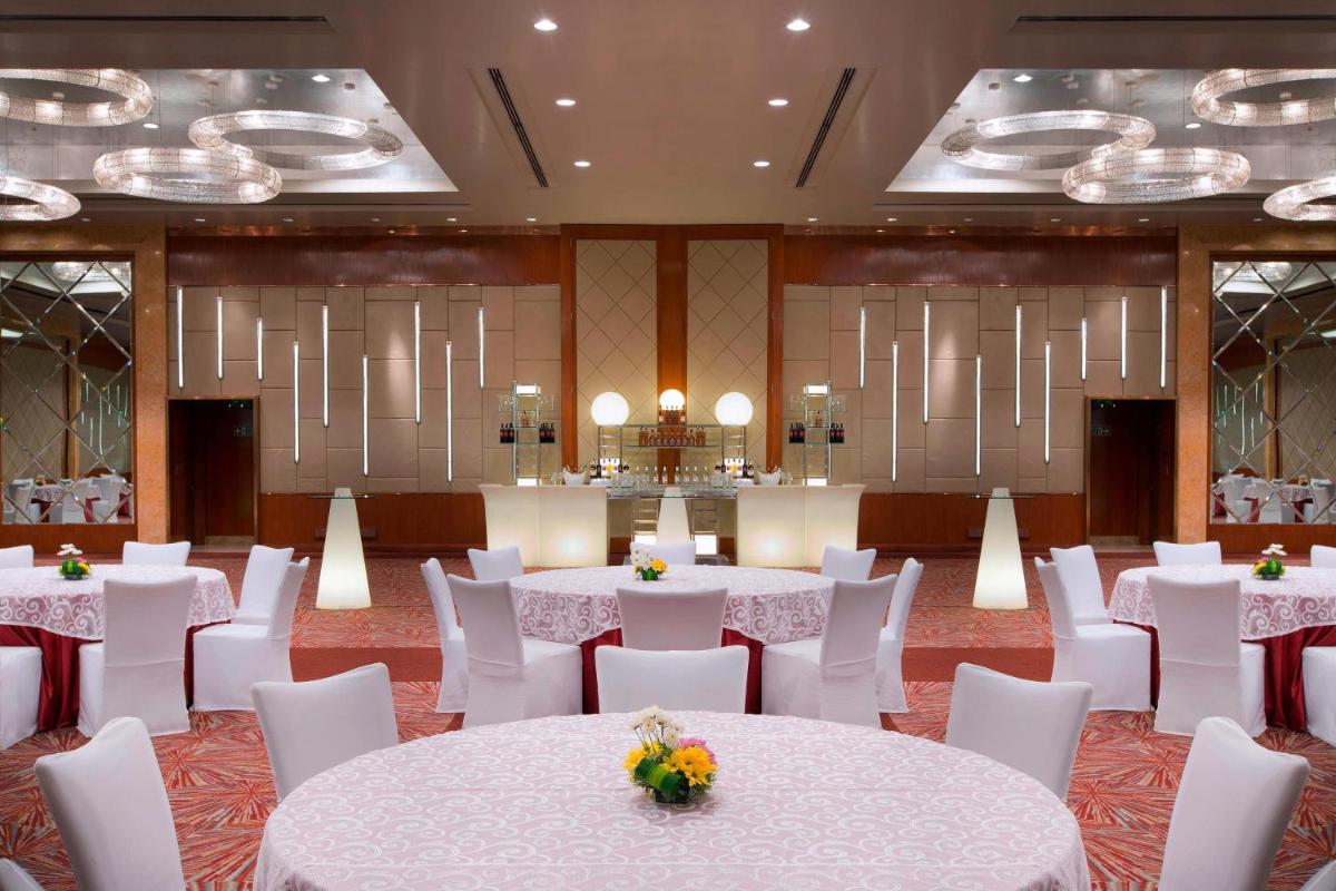 a banquet hall with white tables and white chairs at Sheraton Grand Bangalore Hotel at Brigade Gateway in Bengaluru