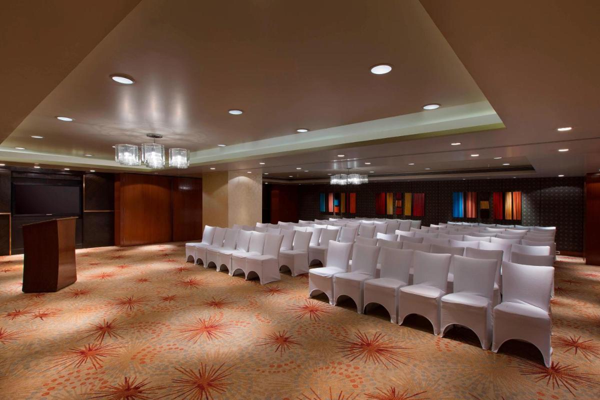 a conference room with white chairs and a podium at Sheraton Grand Bangalore Hotel at Brigade Gateway in Bengaluru