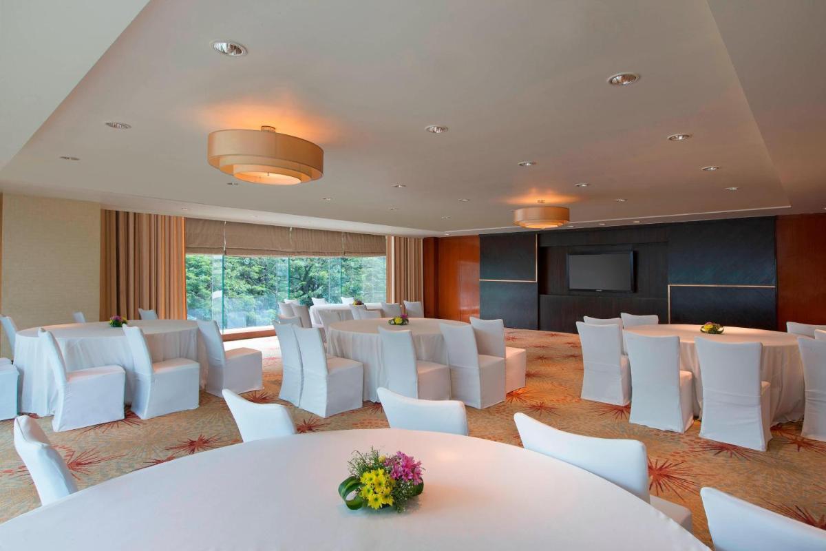 a conference room with white tables and white chairs at Sheraton Grand Bangalore Hotel at Brigade Gateway in Bengaluru