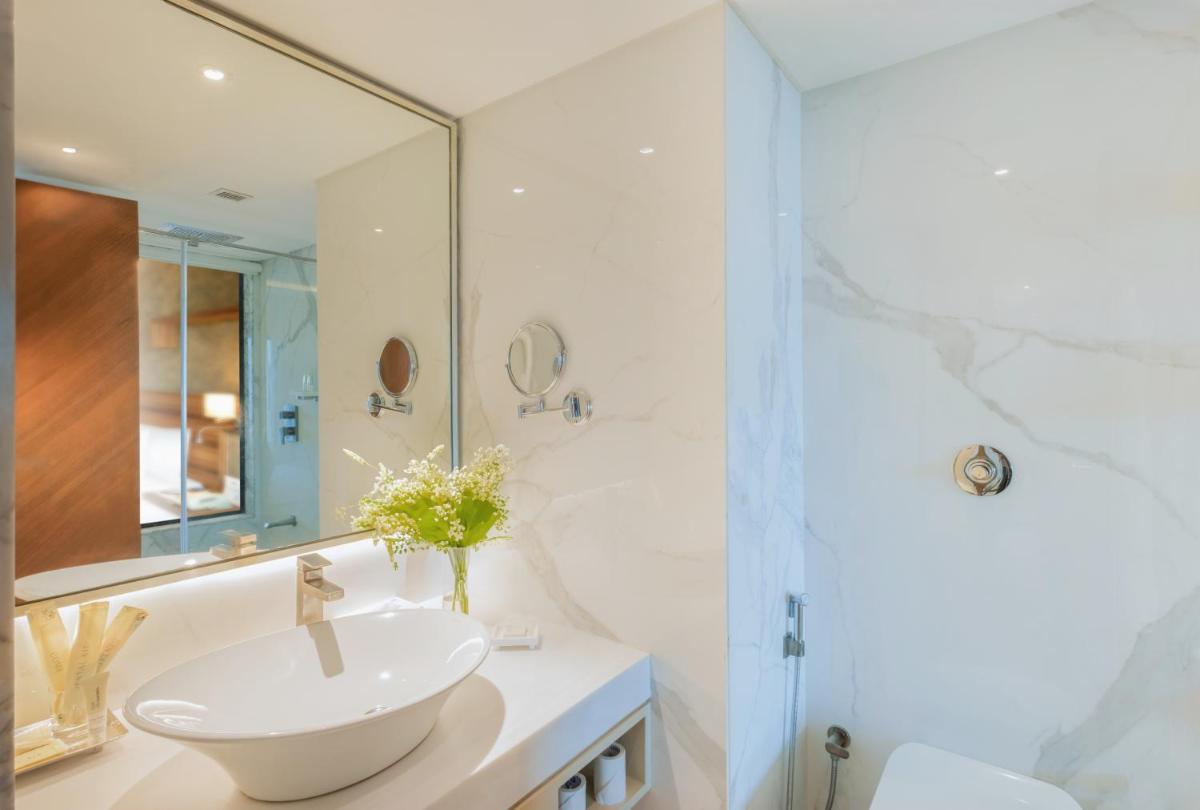a white bathroom with a sink and a shower at Sayaji Pune in Pune