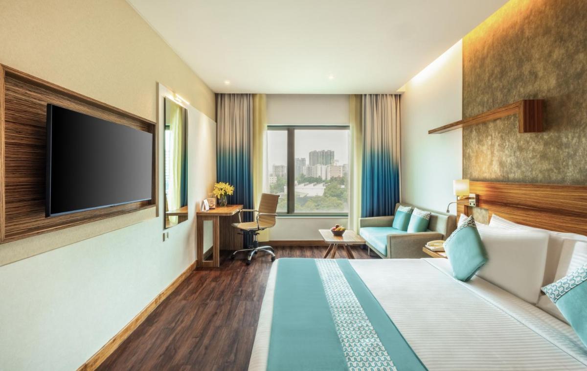 a hotel room with a bed and a tv at Sayaji Pune in Pune