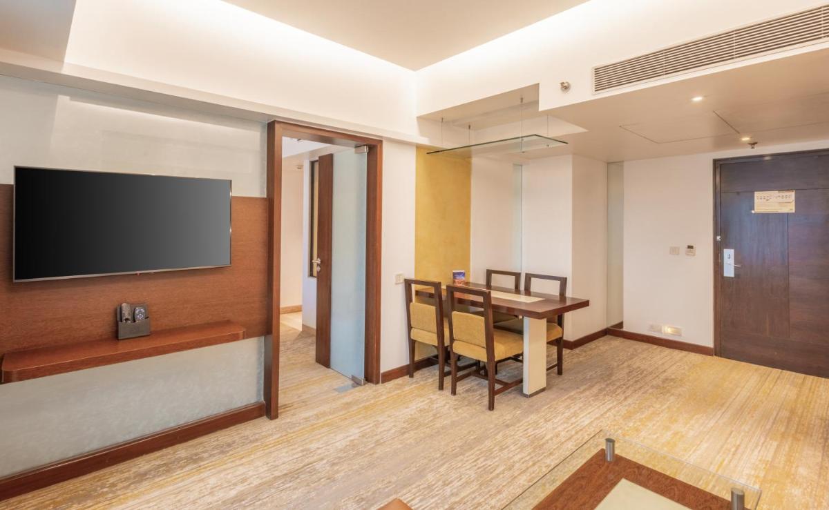 a room with a table and a flat screen tv at Sayaji Pune in Pune