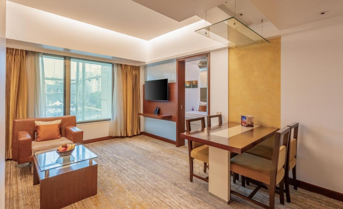 a room with a dining table and a living room at Sayaji Pune in Pune