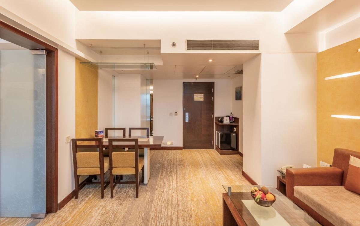 a living room with a table and a couch at Sayaji Pune in Pune