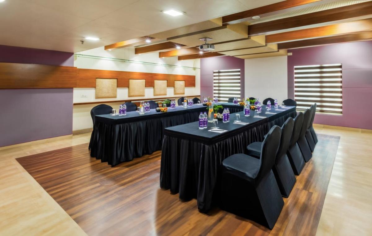 a meeting room with a long table with black chairs at Sayaji Pune in Pune