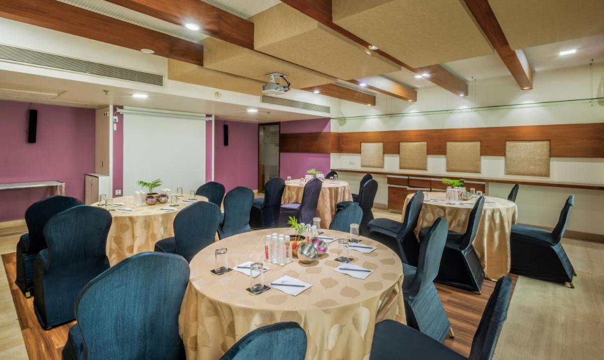 a conference room with round tables and chairs at Sayaji Pune in Pune