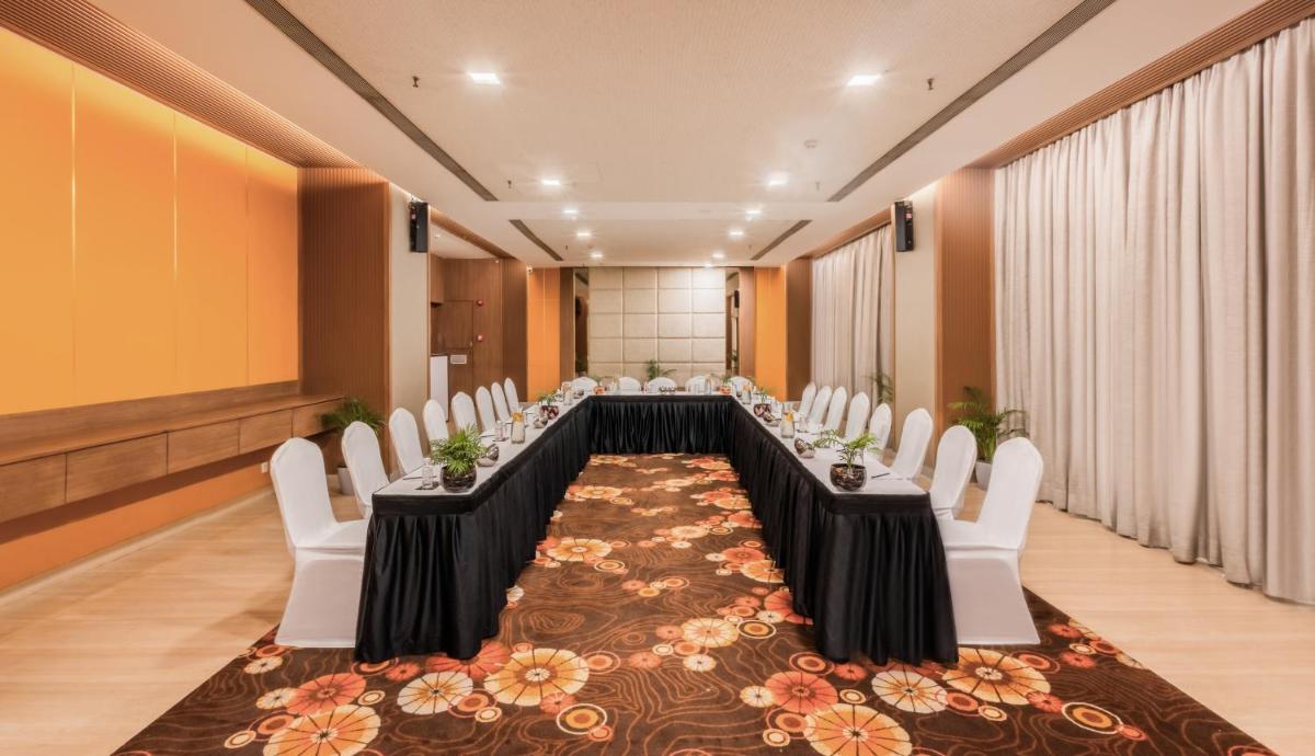 a conference room with a long table and white chairs at Sayaji Pune in Pune
