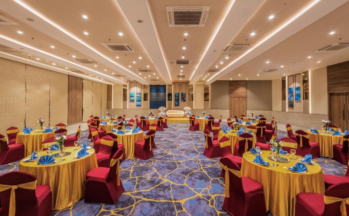 a large banquet hall with tables and chairs at Sayaji Pune in Pune