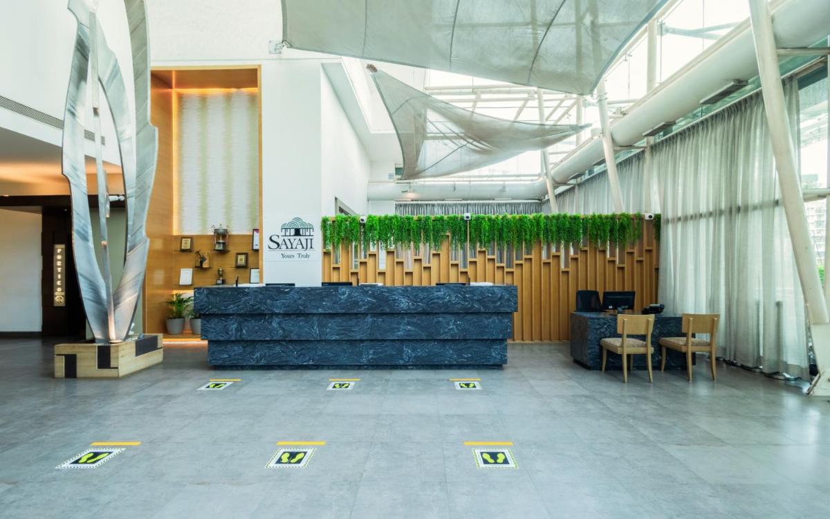 a lobby with a table and chairs in a building at Sayaji Pune in Pune