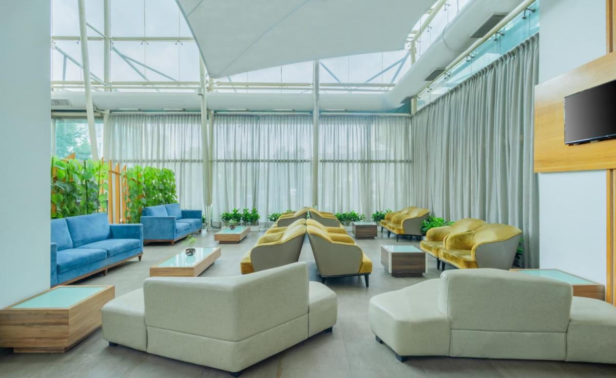 a large living room with couches and chairs at Sayaji Pune in Pune
