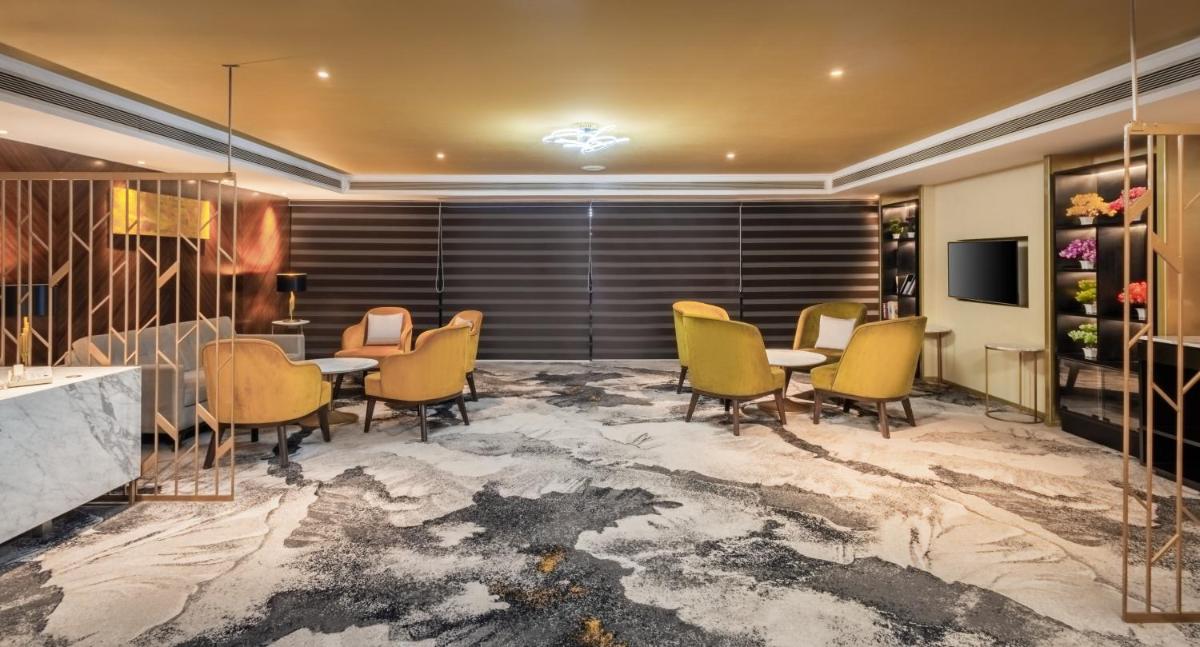 a lobby with chairs and a table and a television at Sayaji Pune in Pune