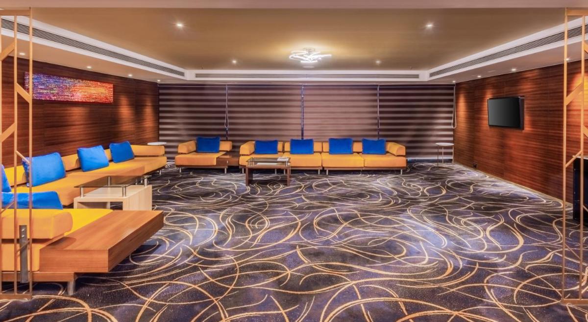 a conference room with blue chairs and a carpet at Sayaji Pune in Pune