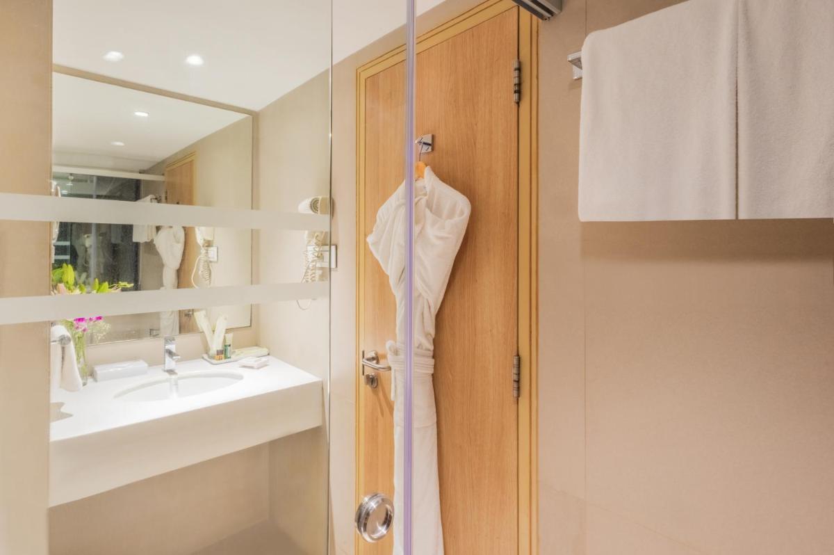 a bathroom with a robe hanging on a door at Sayaji Pune in Pune