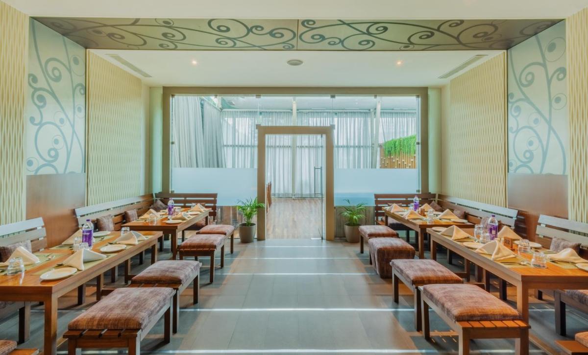 a large dining room with tables and chairs at Sayaji Pune in Pune