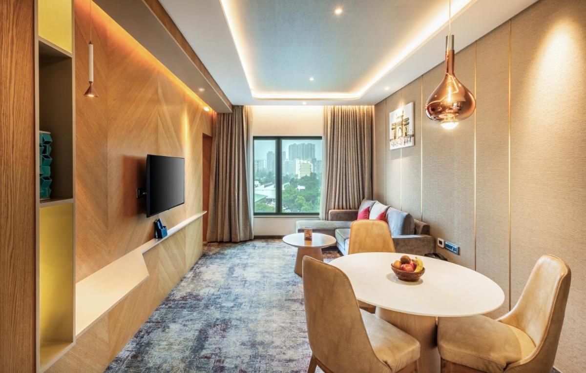 a hotel room with a table and chairs and a couch at Sayaji Pune in Pune