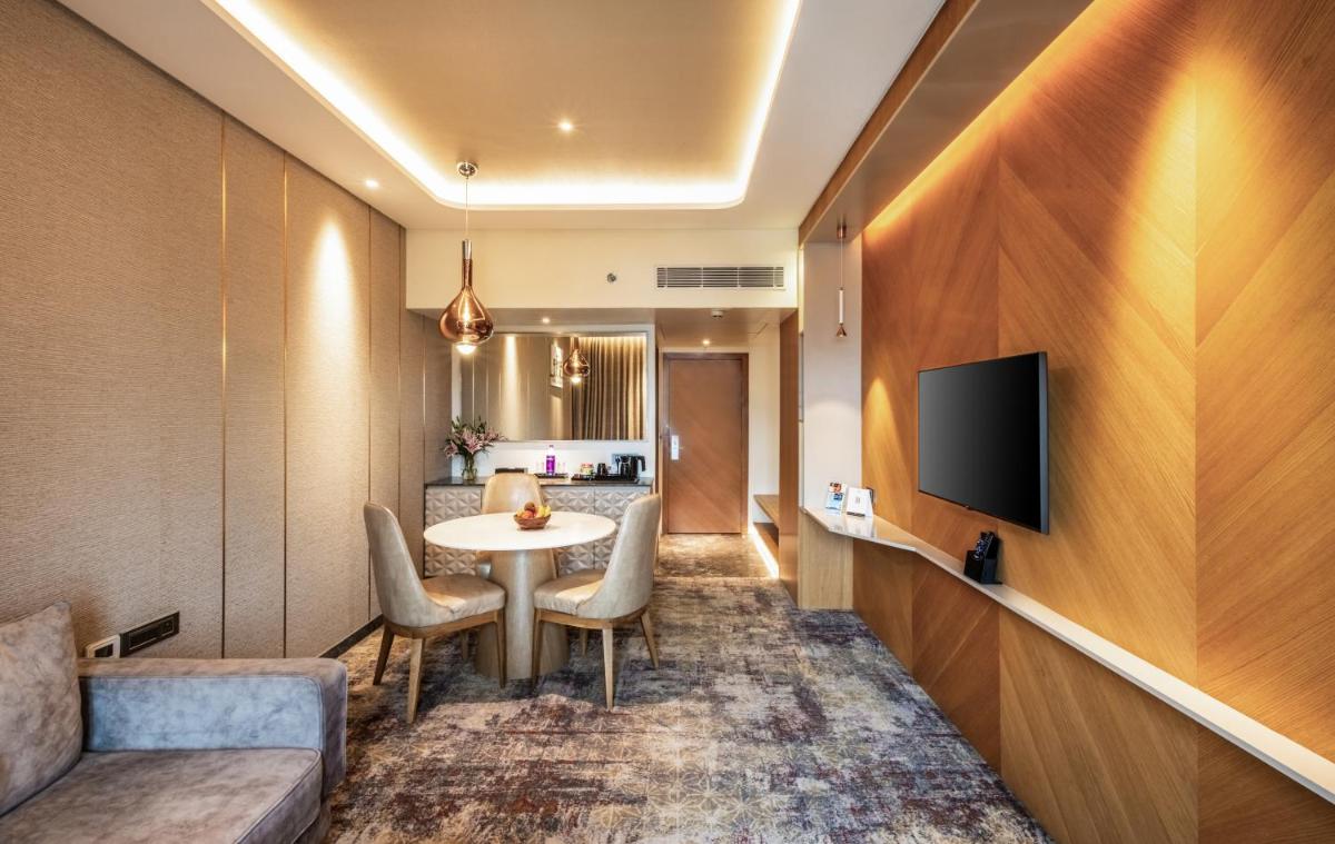 a hotel room with a table and a tv at Sayaji Pune in Pune