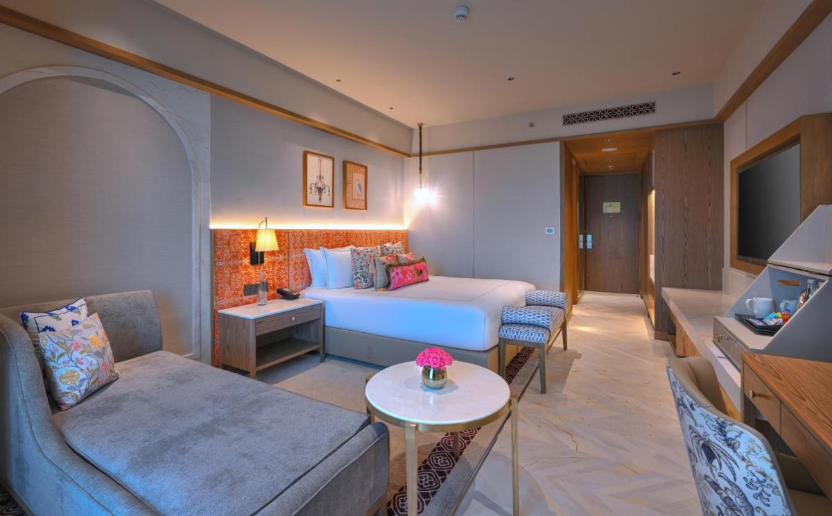 a hotel room with a bed and a couch at Taj Agra in Agra
