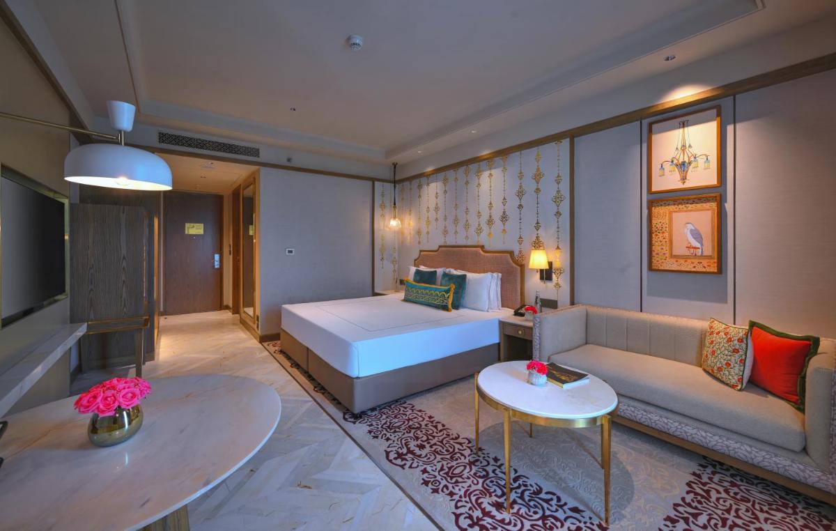 a living room with a bed and a couch at Taj Agra in Agra