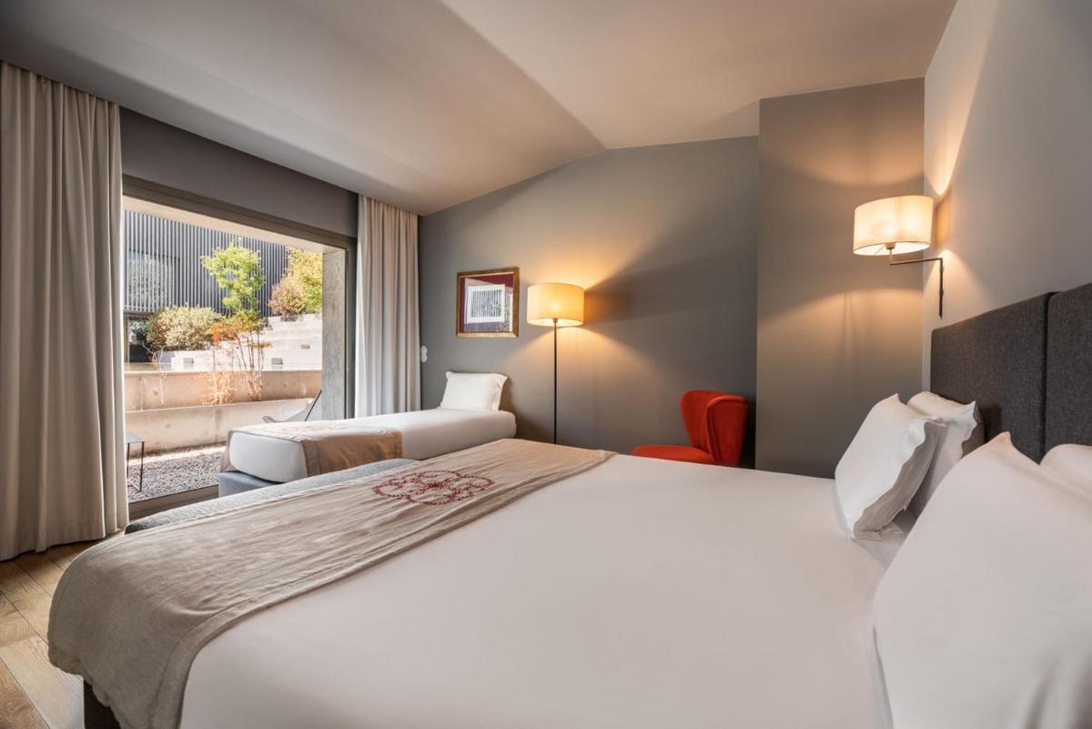 um quarto de hotel com uma cama e uma janela em Eurostars Santa Luzia em Guimarães
