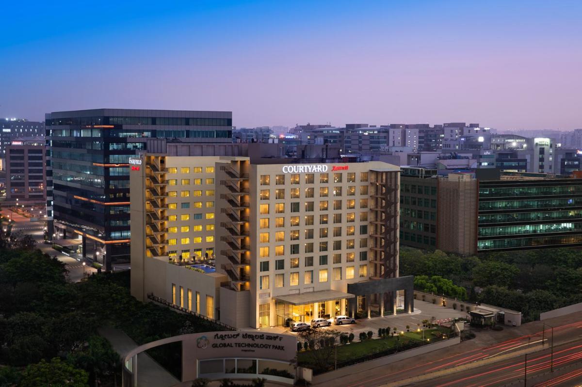 a lit up building in a city at night at Courtyard by Marriott Bengaluru Outer Ring Road in Bengaluru
