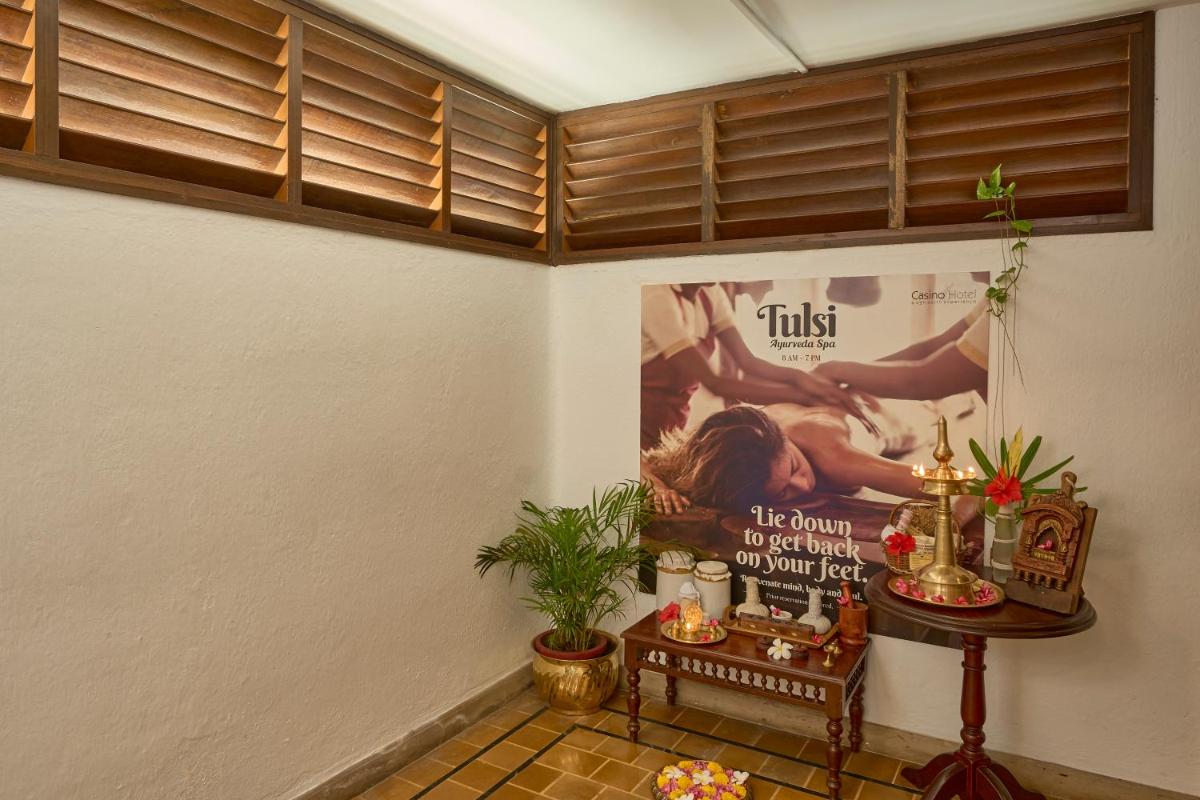 a room with a poster on the wall and a table at Casino Hotel - CGH Earth, Cochin in Cochin