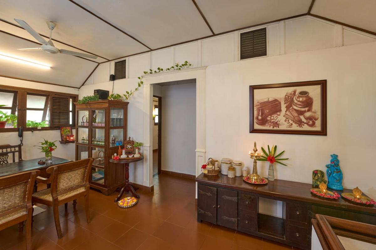 a living room with a table and some chairs at Casino Hotel - CGH Earth, Cochin in Cochin