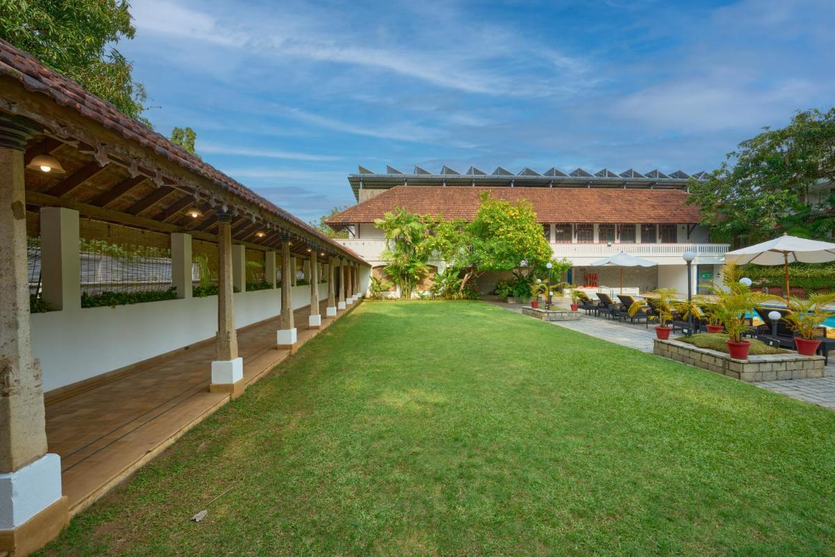 an empty courtyard of a building with a lawn at Casino Hotel - CGH Earth, Cochin in Cochin