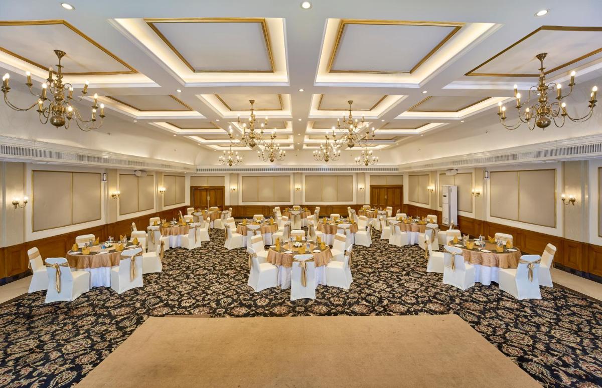 a banquet hall with tables and chairs and chandeliers at Casino Hotel - CGH Earth, Cochin in Cochin +67 photos